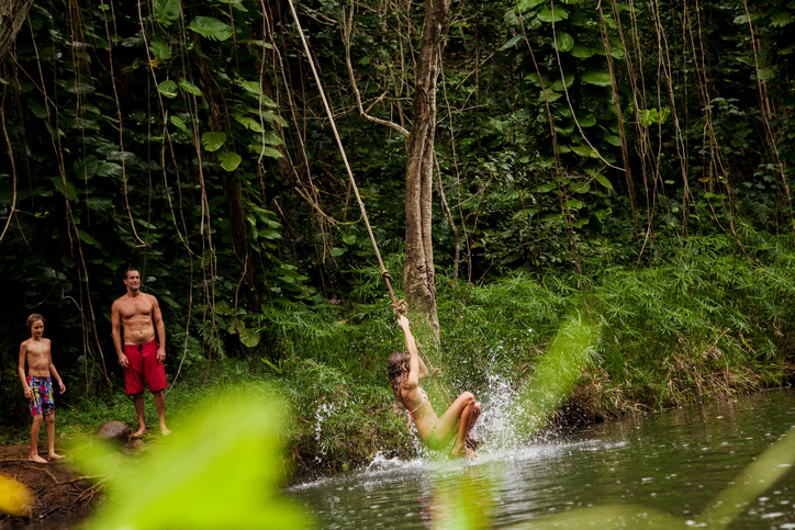 family playing in tropical waters in kauai